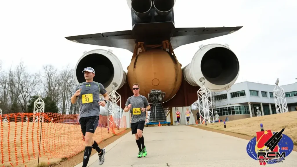 Runners pass a towering spaceship at the Rocket City Marathon in Huntsville.