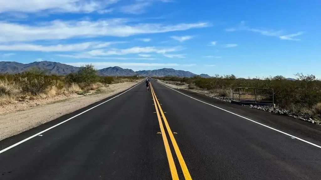 A long road stretches across the desert under the sun at the Buckeye Marathon in Buckeye.