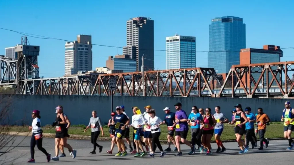 Runners on the road with the cityscape and skyscrapers of Little Rock in the background at the Little Rock Marathon.