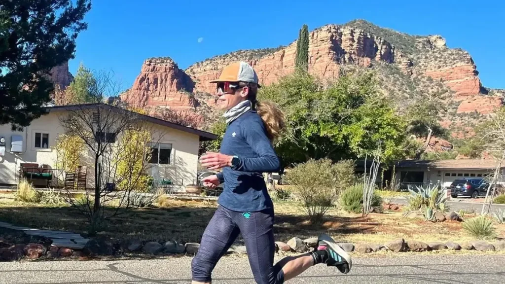 A runner passes a sunlit cliff along the road at the Tucson Marathon in Tucson.