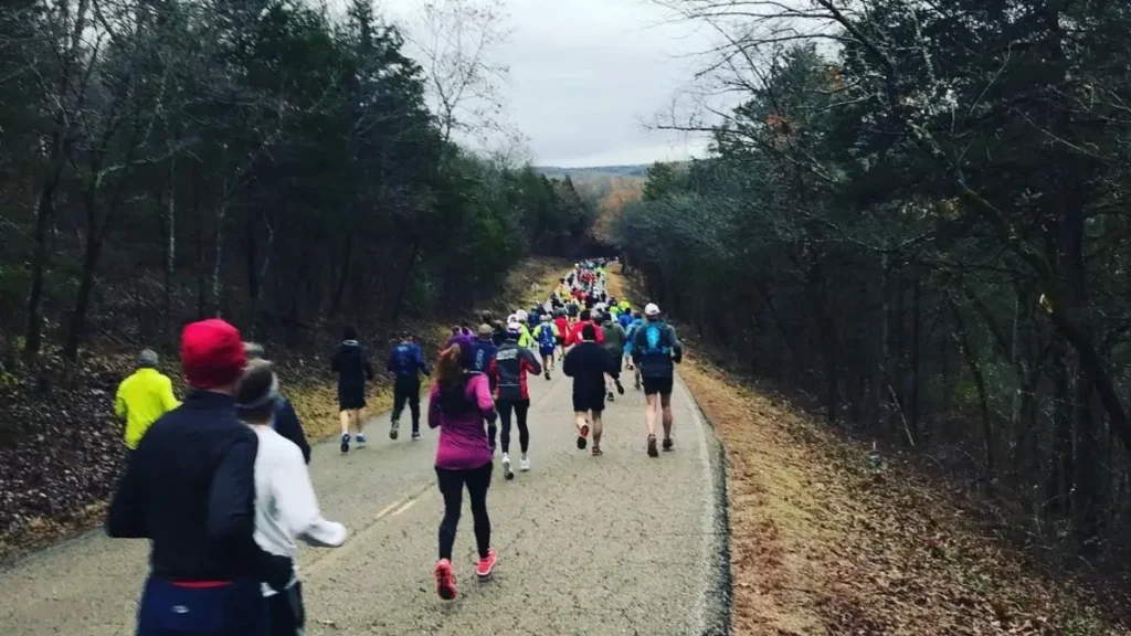 Runners make their way down a forested hill at the White River Marathon for Kenya in Cotter.